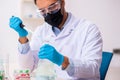 Young male chemist in drug synthesis concept