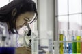 Young chemist woman looking through microscope, working at the laboratory, chemical testing in lab, concept for improving safety Royalty Free Stock Photo