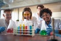 Young chemistry students having a good time in a laboratory while enjoying observing colorful chemical reactions. Science,