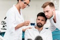 Young chemists in lab coats making working with reagent in laboratory