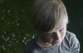 Young child blond boy sad and crying in the garden in summer Royalty Free Stock Photo