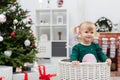 A young child with blonde hair plays by the Christmas tree Royalty Free Stock Photo