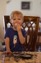 Young child sitting at a table with a marshmallow