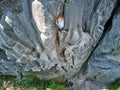 Young child boy climbing steep wall of rocky mountain. Kid climber overcomes challenging route. Engaging in extreme