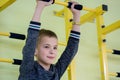 Young child boy exercising on a wall ladder bar inside sports gym room in a school Royalty Free Stock Photo