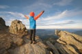 Young child boy hiker standing with raised hands in mountains enjoying view of amazing mountain landscape at sunset Royalty Free Stock Photo