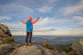 Young child boy hiker standing with raised hands in mountains enjoying view of amazing mountain landscape at sunset Royalty Free Stock Photo