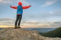 Young child boy hiker standing with raised hands in mountains enjoying view of amazing mountain landscape at sunset Royalty Free Stock Photo