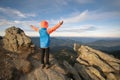 Young child boy hiker standing with raised hands in mountains enjoying view of amazing mountain landscape at sunset Royalty Free Stock Photo