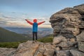 Young child boy hiker standing with raised hands in mountains enjoying view of amazing mountain landscape at sunset Royalty Free Stock Photo