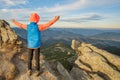 Young child boy hiker standing with raised hands in mountains enjoying view of amazing mountain landscape at sunset Royalty Free Stock Photo