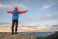 Young child boy hiker standing with raised hands in mountains enjoying view of amazing mountain landscape at sunset Royalty Free Stock Photo