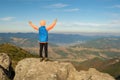 Young child boy hiker standing with raised hands in mountains enjoying view of amazing mountain landscape at sunset Royalty Free Stock Photo