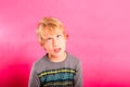 Young child boy making strange faces, rolling his eyes in a grotesque way