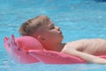 Young child boy relaxing on summer sun swimming on inflatable air mattress in swimming pool during tropical vacations Royalty Free Stock Photo