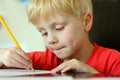 Young Child Drawing on Paper with Pencil