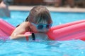 Young child girl relaxing on summer sun swimming on inflatable air mattress in swimming pool during tropical vacations Royalty Free Stock Photo