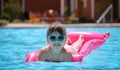 Young child girl relaxing on summer sun swimming on inflatable air mattress in swimming pool during tropical vacations Royalty Free Stock Photo