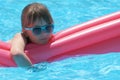 Young child girl relaxing on summer sun swimming on inflatable air mattress in swimming pool during tropical vacations Royalty Free Stock Photo