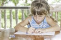 young child girl writing in notebook, outdoors portrait, education idea Royalty Free Stock Photo