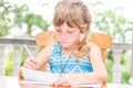 young child girl writing in notebook, outdoors portrait, education idea Royalty Free Stock Photo