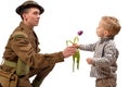 A young child gives a flower to a British soldier