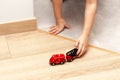 Young child, little girl anonymous kid playing with a small red toy fire truck vehicle, hands pushing a car closeup Royalty Free Stock Photo