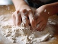 Young child is making dough by mixing it with their hands on top of wooden cutting board