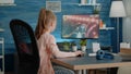 Young child playing action video games on computer at desk Royalty Free Stock Photo