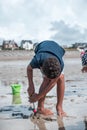 Young child playing on the beach, constructing a sand castle with buckets and spades Royalty Free Stock Photo