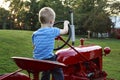 Young Child pretending to drive the red antique tractor