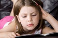 Young Child Reading her Book on the Sofa Royalty Free Stock Photo