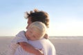 Young Child Resting in Father's Arms on Beach