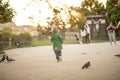 Young Child Running Through Park at Sunset