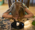 Young child sitting at a table waiting patiently for a marshmallow