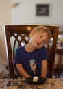 Young child sitting at a table waiting patiently for a marshmallow