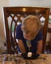 Young child sitting at a table waiting patiently for a marshmallow