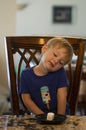 Young child sitting at a table waiting patiently for a marshmallow