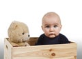 Young child with toy in wooden box