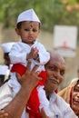 PUNE, MAHARASHTRA, INDIA, June 2017, Young child in white dress sits on his grandfather`s shoulders during Pandharpur festival
