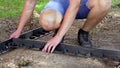 Young children constructing a path, laying delimiter panel