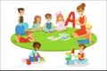 Young Children Learning Alphabet And Playing In Nursery School With Teacher Sitting And Laying On The Floor Royalty Free Stock Photo