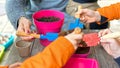 Young children learning how to plant seeds in garden. Narrow depth of field of hands holding seeds and black soil in pot. Royalty Free Stock Photo