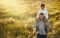 Young children need experiences in the natural world. a mature man carrying his son on his neck.