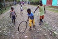 Young children play in the street with homemade toys in rural Haiti.
