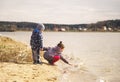 Young children play near the lake. A boy and a girl look at the water in the river Royalty Free Stock Photo