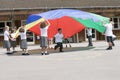 Young children playing with a parachute Royalty Free Stock Photo