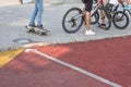 Young children riding skateboards and bikes.