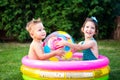 Young children siblings play large inflatable beach ball in courtyard of house in swimming pool. theme of heat and water games,