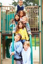 Young Children Sitting On Climbing Frame In Playground